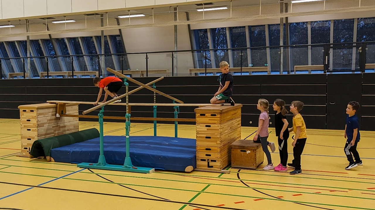 Kinder in der Turnhalle am Hindernisparcours